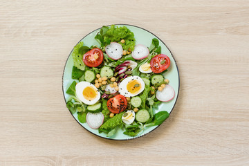 Fresh salad with vegetables and eggs for proper nutrition. Top view, copy space.