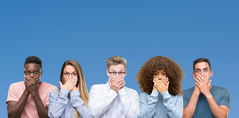 Composition of group of friends over blue blackground shocked covering mouth with hands for mistake. Secret concept.