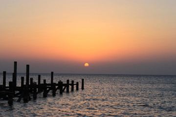 Sunrise on the sea. The sun peeps out from behind the clouds.  Red sea, Safaga, Egypt.