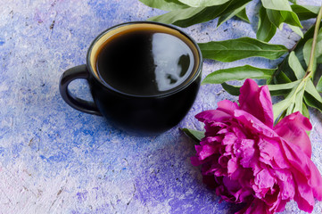 Fototapeta na wymiar raspberry peony and coffee mug on a blue texture surface