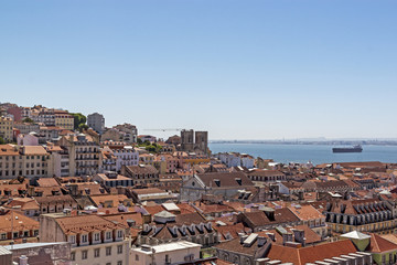 Fototapeta na wymiar The view of the city from view point. The roofs of the houses and the river Tagus. Lisbon, Portugal.