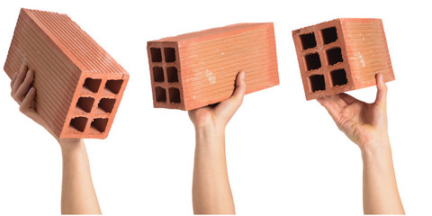 Man hands showing a brick over white background isolated. Builder concept.