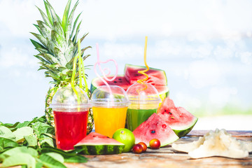 Bright Fresh healthy juices, fruit, pineapple, watermelon on the background of the sea. Summer, rest, healthy lifestyle Copy space