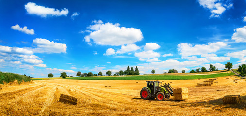 Sommer am Land: Traktor beim Laden von Stroh - obrazy, fototapety, plakaty