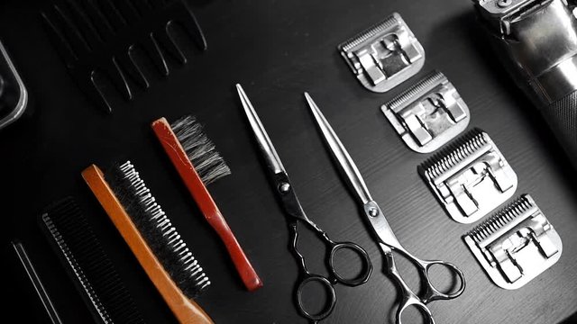 Stylish equipment table with scissors and trimmers and dark scull at the barber shop, making of haircuts, straight razor on the table, shaving salon and barber shop