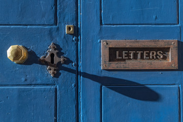 Blue door with vintage brass letter box