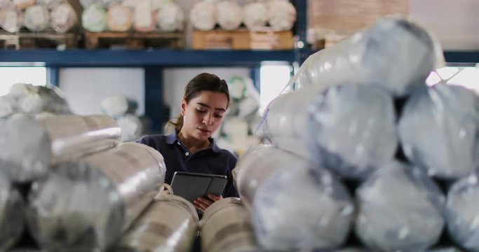 Female working in distribution warehouse with digital tablet