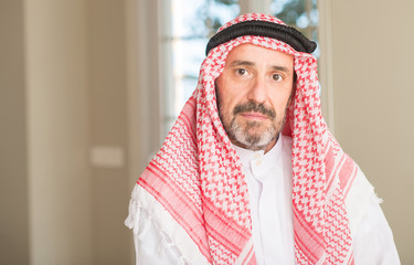Middle age arabian man at home with a confident expression on smart face thinking serious