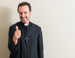 Senior priest religion man happy with big smile doing ok sign, thumb up with fingers, excellent sign