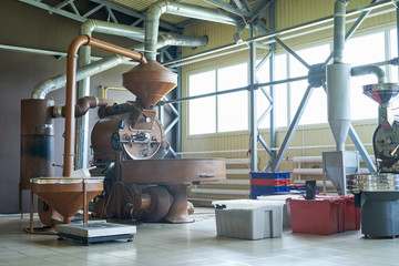Wide angle shot of local roastery house with bronze tinted roasting machines and boxes of coffee...