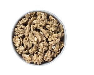 Fototapeta premium Walnut kernels in a bowl, isolated on white background.