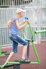 boy teenager engaged in children's exercise equipment