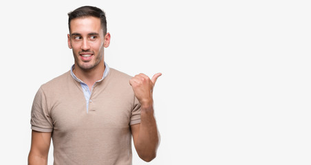 Handsome young man pointing with hand and finger up with happy face smiling