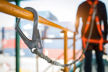 Construction worker wearing safety harness and safety line working at high place