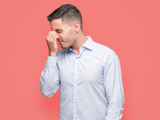 Handsome young businessman tired rubbing nose and eyes feeling fatigue and headache. Stress and...