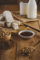 Close up of soybeans in wooden spoon. Soy products such as, milk, tofu and sauce, vintage tone, selective focus
