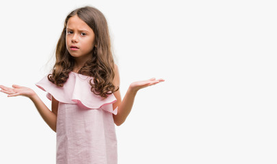 Brunette hispanic girl wearing pink dress clueless and confused expression with arms and hands raised. Doubt concept. © Krakenimages.com