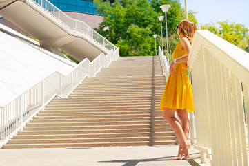 beautiful girl in dress walking along the promenade yellow dress with a pea of happiness. Enjoy the beautiful view. Rostov embankment beautiful;