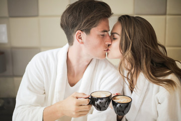 Happy couple with coffee in bed