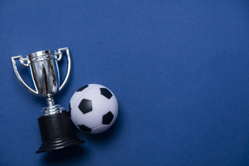 Soccer ball with a silver winning trophy