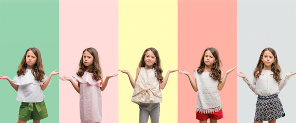 Collage of brunette hispanic girl wearing different outfits clueless and confused expression with arms and hands raised. Doubt concept. © Krakenimages.com