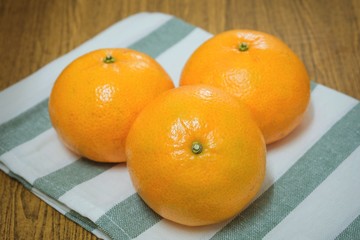 Three Ripe Oranges on A Wooden Table