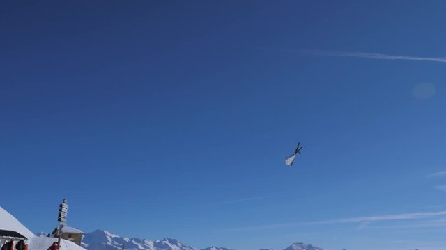 Helicopter Flies Low In The Mountains Above His Head In Clear Sunny Weather
