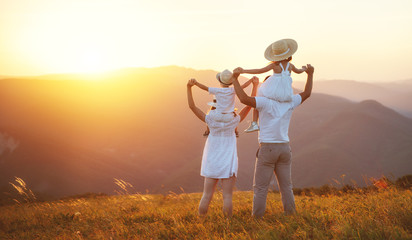 Happy family: mother, father, children son and daughter on sunset