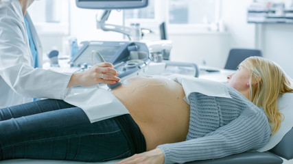 In the Hospital, Pregnant Woman Getting Sonogram / Ultrasound Screening / Scan, Obstetrician Checks Picture of the Healthy Baby on the Computer Screen. Doctor Talks with Happy Future Mother.