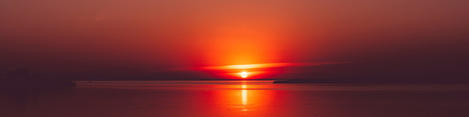 Obraz premium panorama. red sky at sunset by the sea.