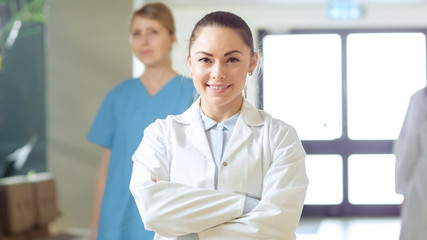 Beautiful Young Female Doctor Walks Through the Hospital Hallway, She Stops, Crosses Arms and...