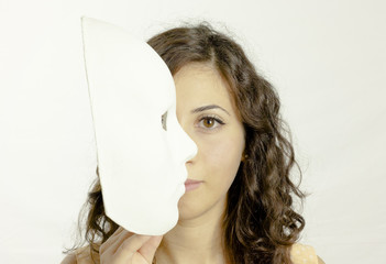A cute girl hiding half her face under a bright white mysterious mask. Proud self-confident...