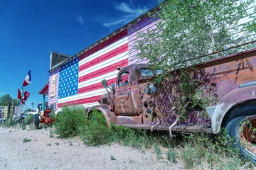 Rugzak SELIGMAN, AZ - 29 JUNI, 2018: Oude vrachtwagen en Amerikaanse vlag langs Route 66. Dit is de beroemdste historische route in de VS © jovannig