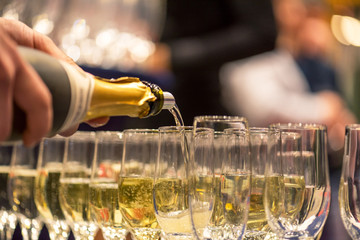 Bartender pouring champagne into glass.
