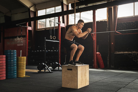 Young sportsman is jumping on the box