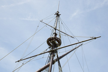 High wooden masts sailboat on cloud blue sky