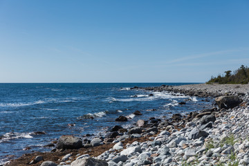 Rocky beach on a bright sunny summer day with a clear blue sky