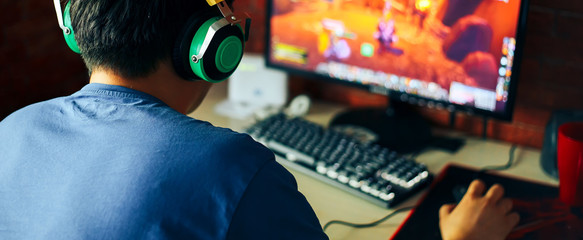 young man playing game on computer, banner - obrazy, fototapety, plakaty