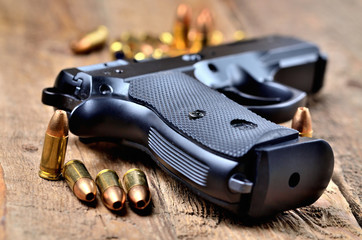 Obraz premium 9mm pistol and bullets on old wooden table