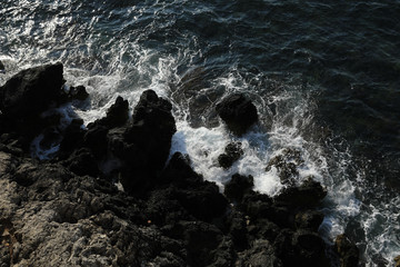 Waves break against rocks of the medieval castle town of Monemvasia, Aegean sea, Peloponnese, Greece, June 2018.