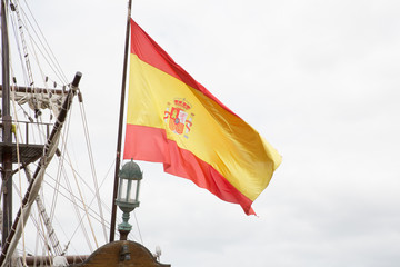 Detail of mast of ship with spain flag in wind