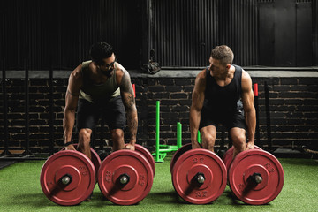 Muscular men during competition in the farmer's walk exercise