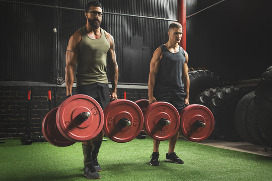 Muscular men during competition in the farmer's walk exercise