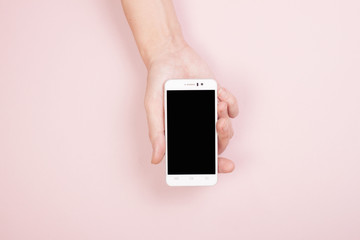A hand holds a smartphone on a pink background. Blank Screen