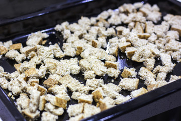 Crackers for Caesar salad. Pieces of bread on a baking tray for the oven