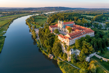 Fototapeta Tyniec near Krakow, Poland. Benedictine abbey, monastery and church on the rocky cliff and Vistula river. Aerial view at sunset. Bielany monastery far in the background obraz