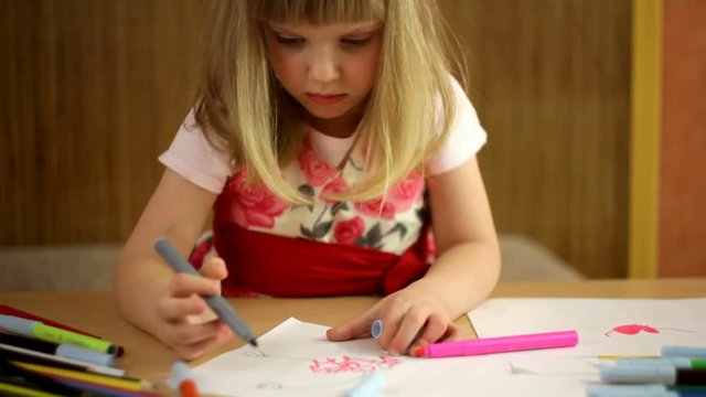cheerful girl child draws with colored inks