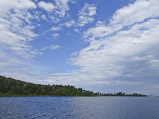 Summer landscape: blue sky and cirrus clouds over the lake on a sunny day