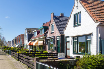 Village Oudeschild with a row of  trraditional fisherman houses on Texel island in the Netherlands - obrazy, fototapety, plakaty