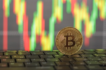 Gold bitcoin and keyboard close-up on blurred background
